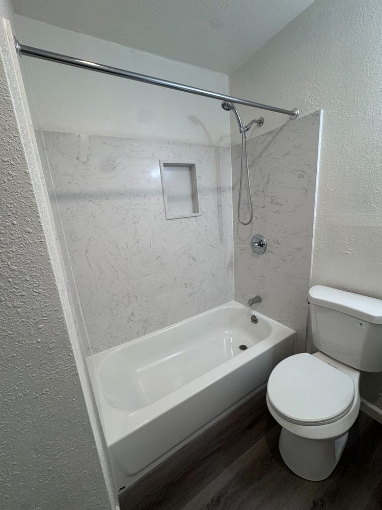 Renovated bathroom with new tub surround and toilet