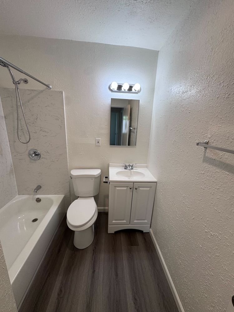 Renovated bathroom with new vanity, mirror, light fixture and tub