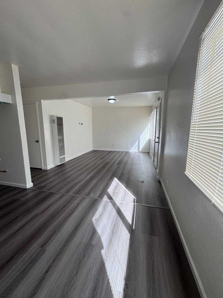 Sunlit living area with new plank flooring and fresh paint